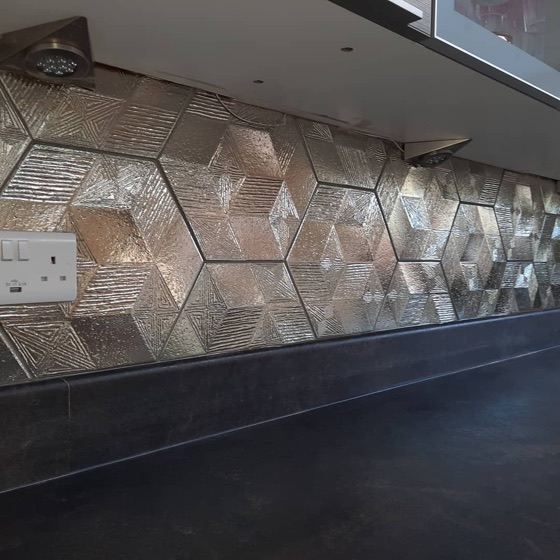 Three dimensional hexagon feature tile catching the light on a bathroom wall