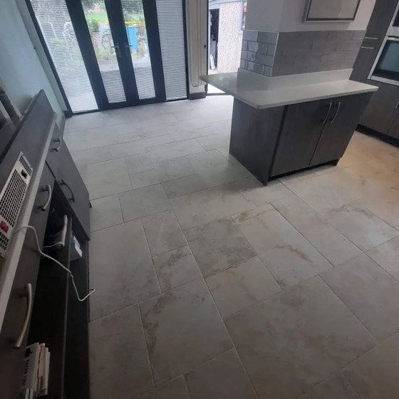 Tiled floor running through a kitchen and dining area out to bifold doors