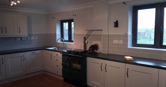 Tiled splashback behind a range cooker in a cream kitchen