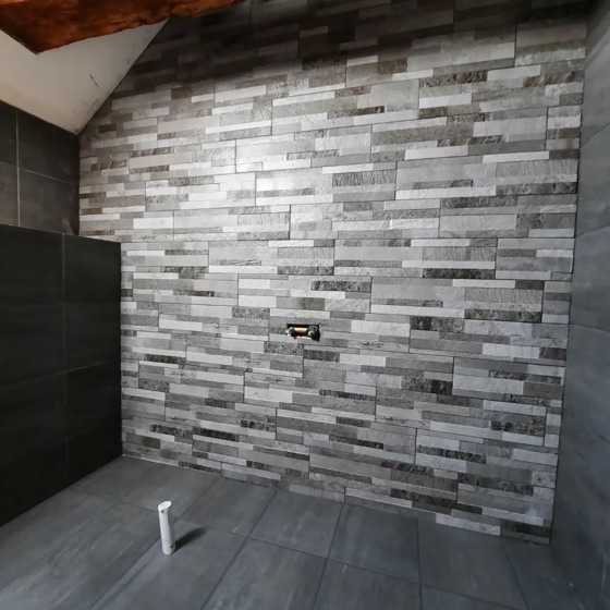 Imitation split face tile used as a feature wall against a matt dark floor